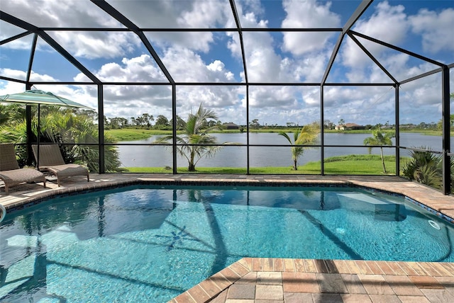 outdoor pool with a water view, glass enclosure, and a patio