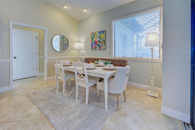 dining room with lofted ceiling, light tile patterned floors, and baseboards