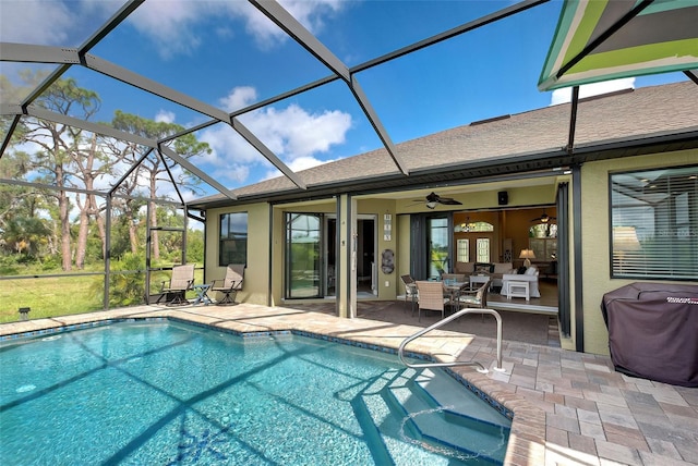 outdoor pool featuring glass enclosure, a grill, a patio area, and ceiling fan