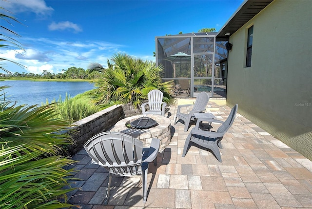 view of patio with a lanai, a water view, and a fire pit