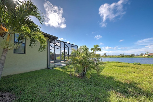 view of yard featuring glass enclosure and a water view