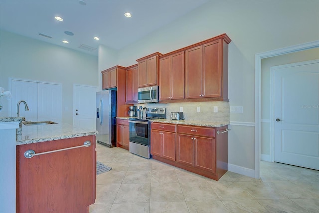 kitchen featuring tasteful backsplash, appliances with stainless steel finishes, visible vents, and light stone countertops