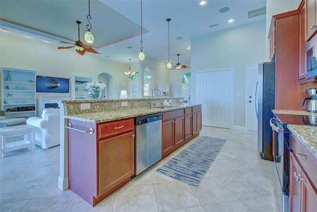 kitchen with visible vents, an island with sink, open floor plan, decorative light fixtures, and stainless steel appliances