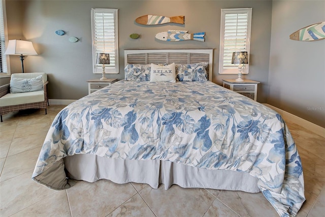 tiled bedroom featuring multiple windows and baseboards