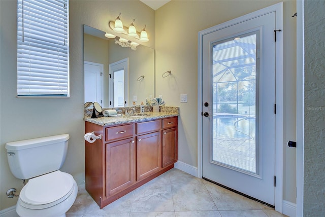 bathroom featuring tile patterned flooring, baseboards, vanity, and toilet