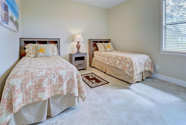 bedroom with light tile patterned floors and baseboards