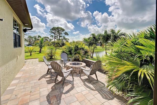 view of patio / terrace featuring an outdoor fire pit and a water view