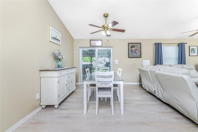 dining space featuring ceiling fan, vaulted ceiling, and light hardwood / wood-style flooring