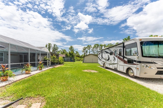 view of yard featuring a swimming pool and glass enclosure