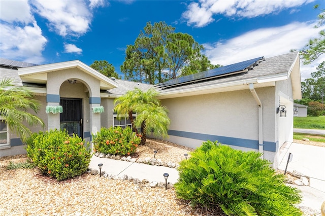 ranch-style house with a garage and solar panels