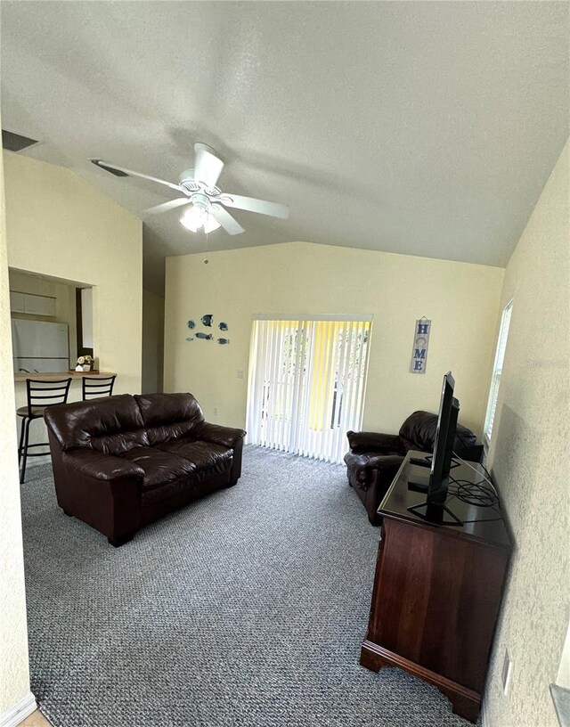 living room with ceiling fan, a textured ceiling, carpet floors, and lofted ceiling