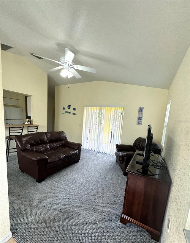 carpeted living room with visible vents, lofted ceiling, and a textured ceiling