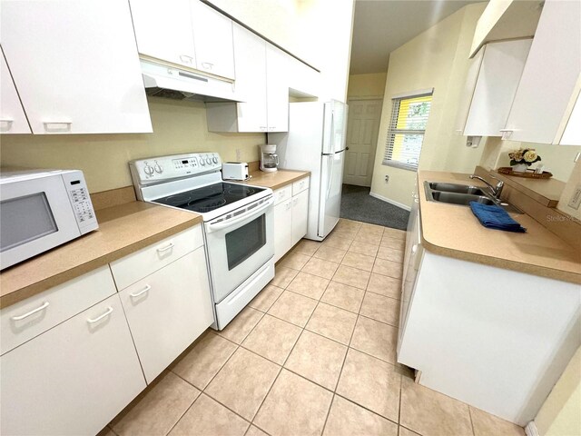 kitchen with sink, custom range hood, white appliances, light tile patterned floors, and white cabinets