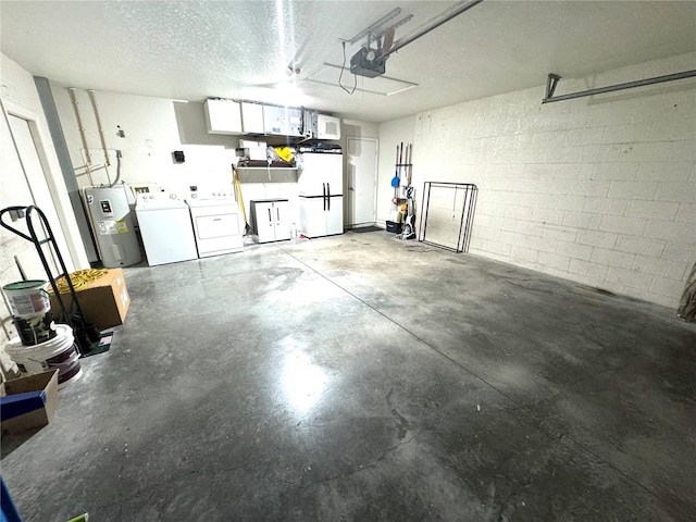 garage with washer and clothes dryer, water heater, a garage door opener, freestanding refrigerator, and concrete block wall