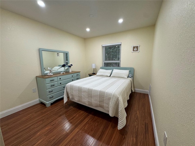 bedroom with a textured wall, recessed lighting, baseboards, and dark wood-style flooring