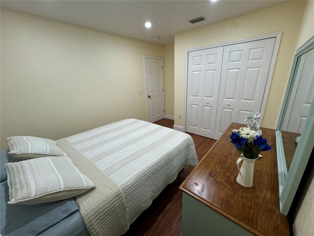 bedroom featuring dark hardwood / wood-style floors and a closet