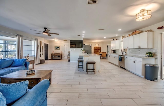 kitchen featuring visible vents, white cabinetry, open floor plan, and stainless steel appliances