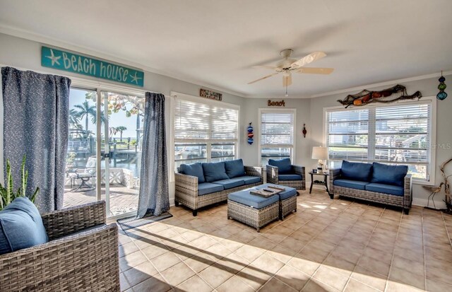 living room featuring ceiling fan, ornamental molding, and light tile patterned floors