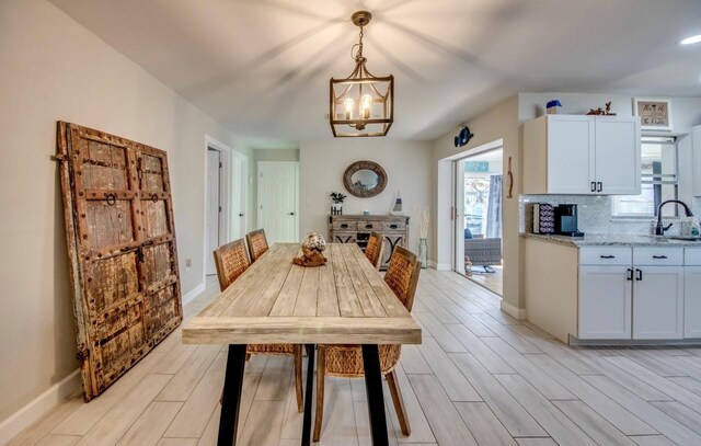 dining space with baseboards, wood finish floors, and a chandelier