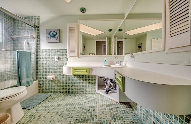 bathroom featuring toilet, a shower with shower door, tile patterned flooring, vanity, and tile walls