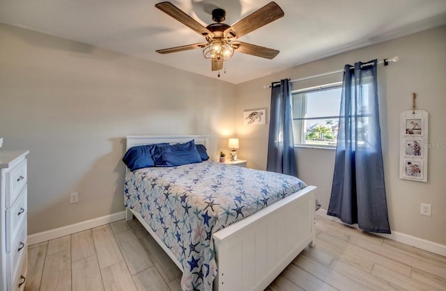 bedroom featuring light wood-style floors, baseboards, and a ceiling fan