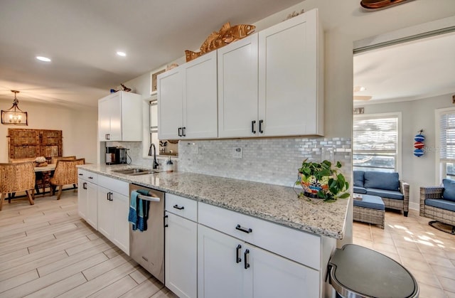 kitchen featuring white cabinets, decorative backsplash, dishwasher, and sink