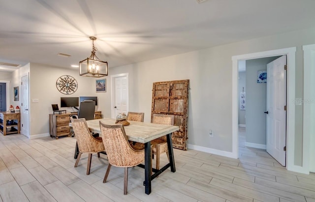 dining room featuring a notable chandelier and light wood-type flooring