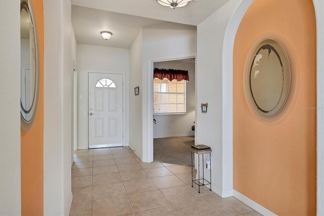 entrance foyer featuring light tile patterned flooring, light carpet, and baseboards