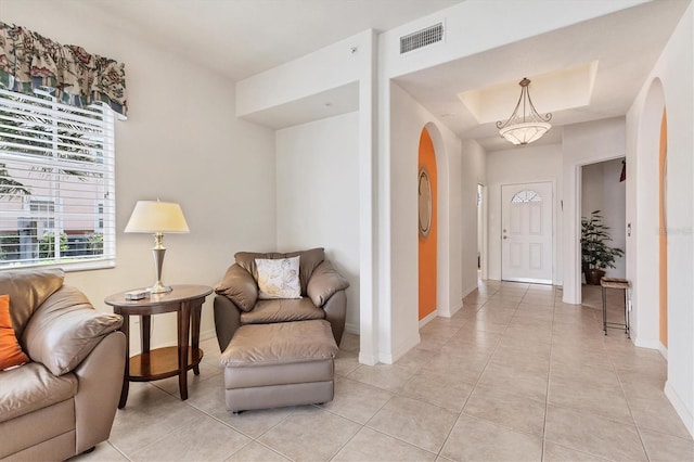 interior space featuring visible vents, arched walkways, baseboards, and light tile patterned flooring