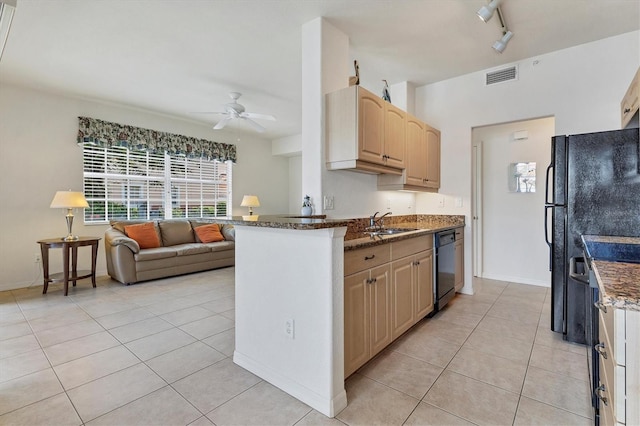 kitchen with light tile patterned floors, black dishwasher, visible vents, dark stone counters, and light brown cabinetry