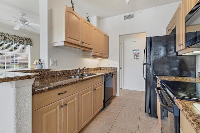 kitchen featuring visible vents, light tile patterned flooring, a sink, dark stone countertops, and black appliances