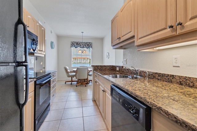 kitchen featuring black appliances, light brown cabinetry, a sink, and pendant lighting