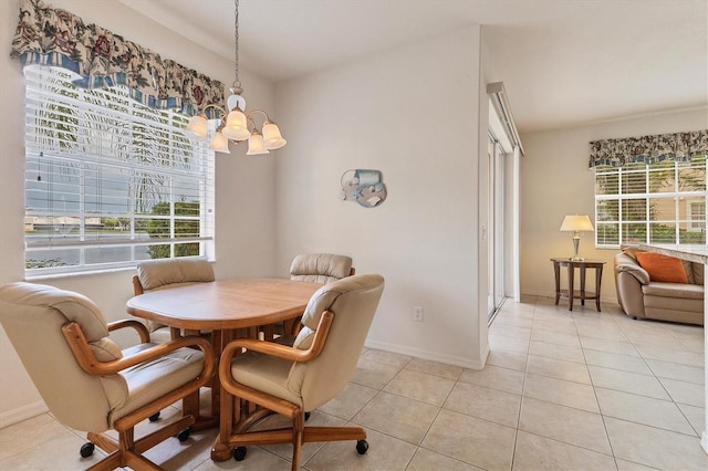 dining space featuring light tile patterned floors, a chandelier, and baseboards