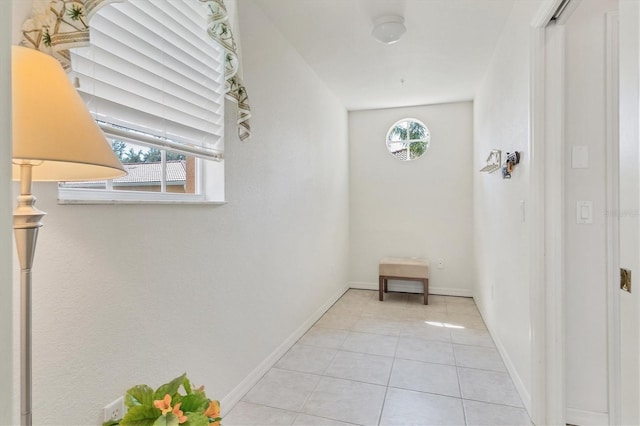 hallway with light tile patterned flooring and baseboards