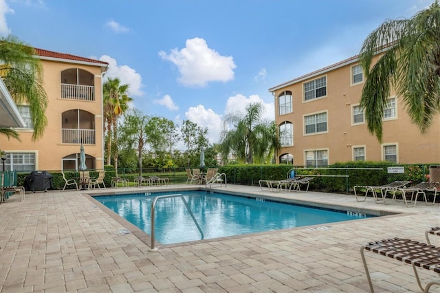 community pool featuring fence and a patio