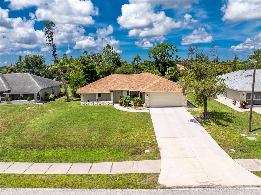 view of front of house with concrete driveway, a front lawn, roof with shingles, and an attached garage