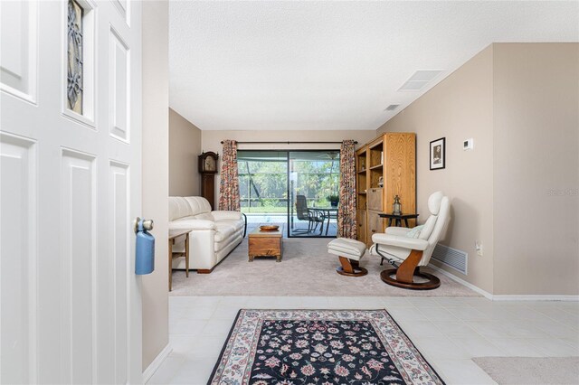 living room featuring a textured ceiling and light carpet