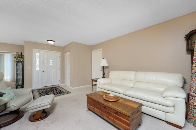 carpeted living area with a textured ceiling and baseboards