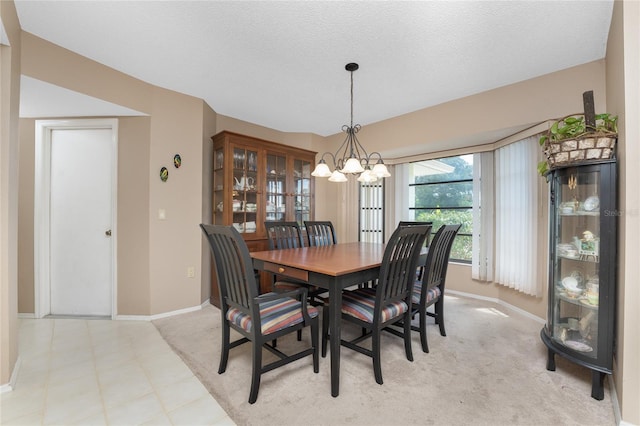 dining space featuring a notable chandelier, baseboards, and a textured ceiling