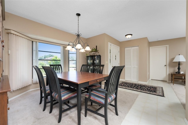 dining area featuring a chandelier, a textured ceiling, and baseboards