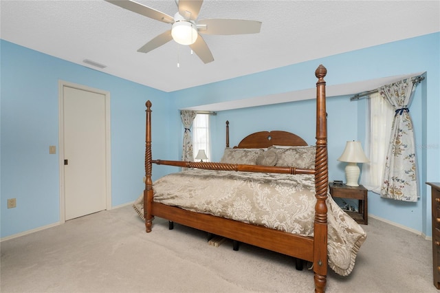 bedroom with visible vents, baseboards, ceiling fan, a textured ceiling, and carpet floors