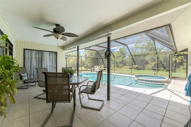 view of swimming pool featuring glass enclosure, ceiling fan, outdoor dining area, a patio area, and a pool with connected hot tub