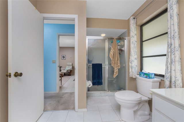 bathroom featuring toilet, a stall shower, tile patterned flooring, and vanity