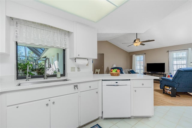 kitchen featuring light countertops, white cabinetry, white dishwasher, a sink, and a peninsula