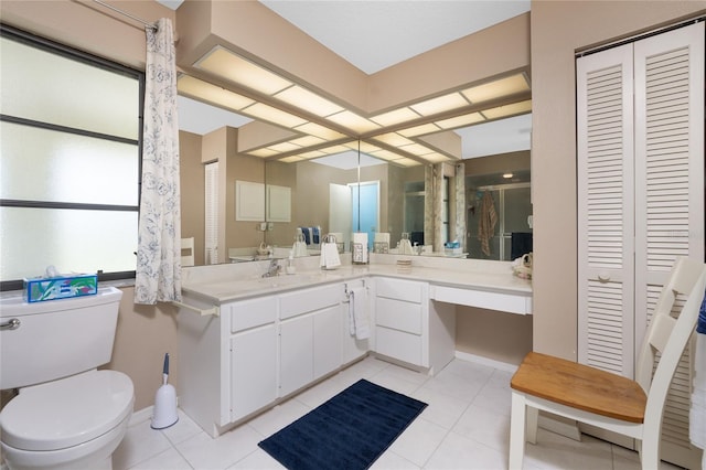 bathroom featuring toilet, vanity, a closet, and tile patterned floors