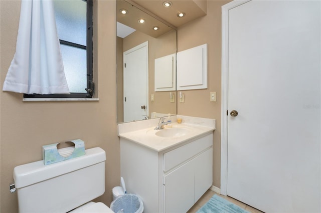 bathroom featuring vanity, toilet, and recessed lighting