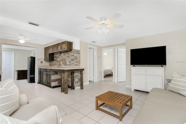 tiled living room with sink and ceiling fan