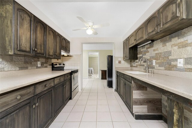 kitchen featuring sink, stainless steel electric stove, dark brown cabinets, tasteful backsplash, and ceiling fan