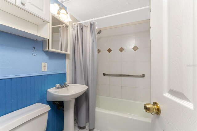 bathroom with tile patterned flooring, shower / bath combination with curtain, and toilet