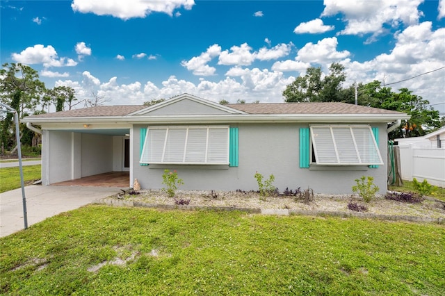 ranch-style home featuring a carport and a front yard